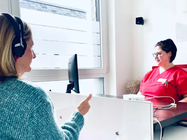 Arzthelferin mit Patientin während eines Hörtests